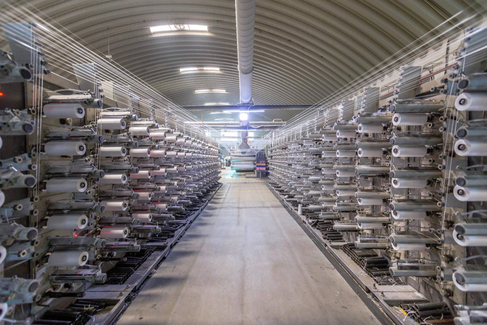 Rows of circular looms weaving polypropylene fabric in the Pegma loom hall